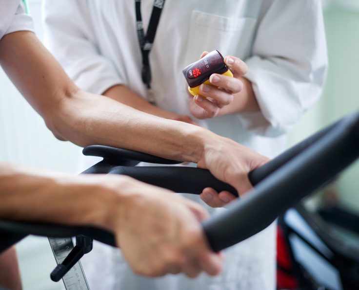 Doctor checking patient's heart rate during a treadmill test