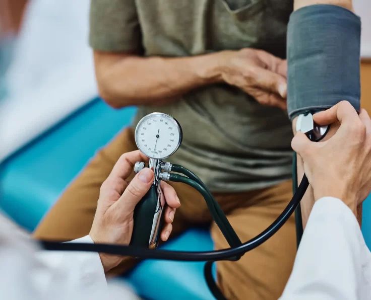 Close up of doctor measuring blood pressure of an elderly patient.