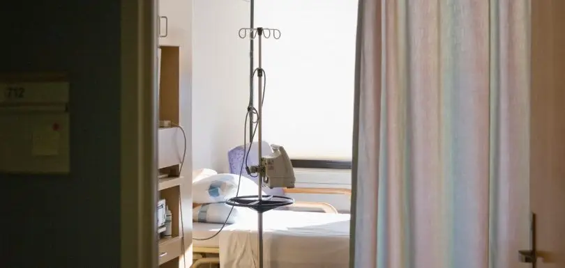 Hospital room with bed and privacy curtain.