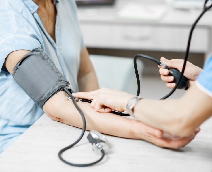 Nurse measuring blood pressure of a senior patient