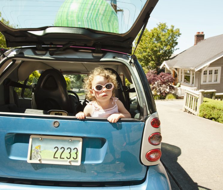 Young girl in back of smart car