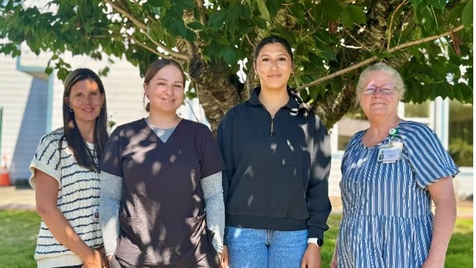 Kelly Thompson, CNO; Taz Wachendorf, MAC, Clallam Bay Medical Clinic; Sylvia Torres, NAC, Extended Care Unit and Acute Care; and Deborah Dillon, Director of Patient Safety & Quality pose in front of a tree.