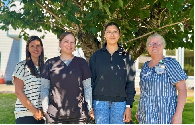 Kelly Thompson, CNO; Taz Wachendorf, MAC, Clallam Bay Medical Clinic; Sylvia Torres, NAC, Extended Care Unit and Acute Care; and Deborah Dillon, Director of Patient Safety & Quality pose in front of a tree.